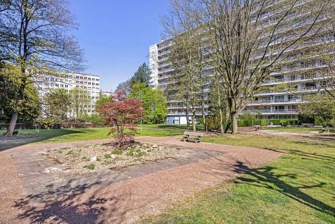Dit appartement met twee slaapkamers en een ruim westgericht terras van 18 m² ligt op een toplocatie in de wijk Roodebeek, vlak bij het trein- en metrostation Roodebeek en achter het befaamde Woluwe Shopping Center. Het gebouw bevindt zich in een groene,