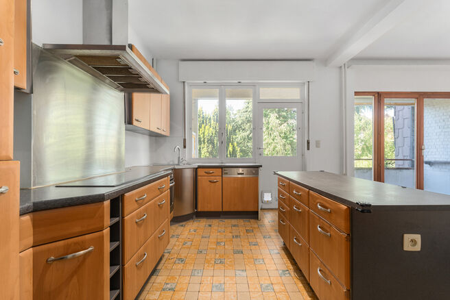 Tweegezinswoning bestaande uit een appartement en een duplex appartement, met garage, tuin en terrassen.
Het gebouw heeft in totaal 8 slaapkamers en 3 badkamers.

INDELING:
Op de eerste verdieping bevindt zich een appartement met &eacute;&eacute;n slaapkamer en een t