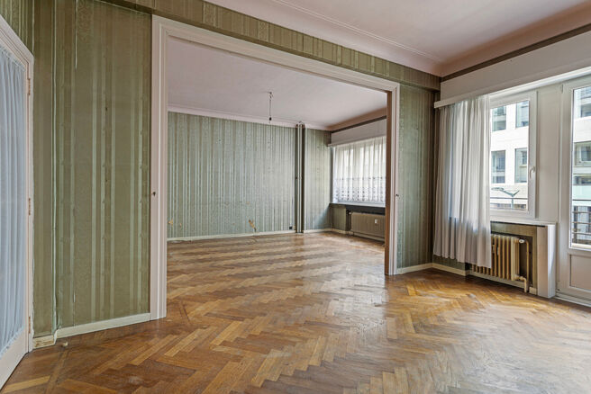This classy one-bedroom apartment with 2 terraces and 2 spacious attic storerooms is located on the 2nd floor of a co-ownership building, perfectly situated in the European Quarter, between Schuman and Brussels Park.

The apartment is arranged as follows: