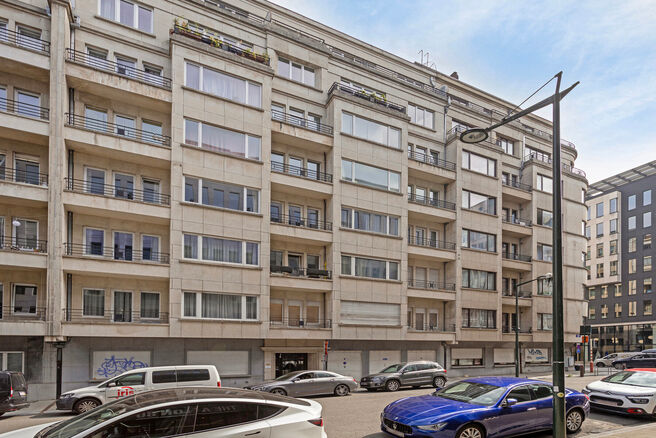 This classy one-bedroom apartment with 2 terraces and 2 spacious attic storerooms is located on the 2nd floor of a co-ownership building, perfectly situated in the European Quarter, between Schuman and Brussels Park.

The apartment is arranged as follows: