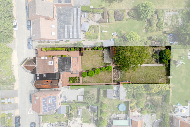 Deze karaktervolle burgerwoning in Vlaamse neotraditionele stijl, met haar statige trapgevel en authentieke elementen, ligt op een royaal perceel van 860 m² in het landelijke Beigem (Grimbergen).

Op het gelijkvloers bevindt zich de inkomhal die toegang 