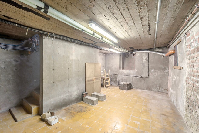 Deze hoekwoning met 3 slaapkamers en garage is centraal gelegen, op wandelafstand van de dorpskern van Machelen.

INDELING:
Op het gelijkvloers bevindt zich de voormalige slagerswinkel. Verder vindt u een ruime eetkamer of bureau aan de voorzijde, een woo