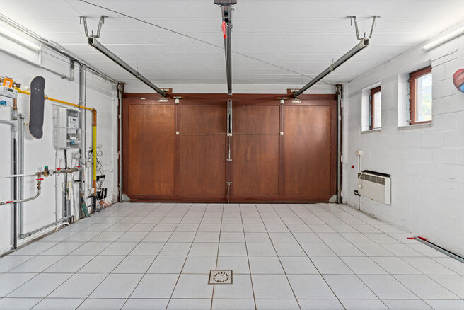 Deze ruime villa met maar liefst 5 slaapkamers en 3 badkamers is gelegen in een residenti&euml;le woonwijk, op een perceel van 15a85ca.

Bij het betreden van de woning komt men in de inkomhal met apart gastentoilet. In 2002 werd de woning uitgebreid met een a
