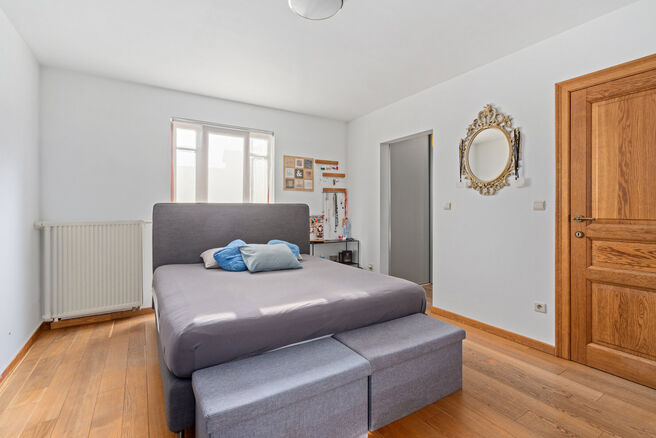 Deze ruime villa met maar liefst 5 slaapkamers en 3 badkamers is gelegen in een residenti&euml;le woonwijk, op een perceel van 15a85ca.

Bij het betreden van de woning komt men in de inkomhal met apart gastentoilet. In 2002 werd de woning uitgebreid met een a