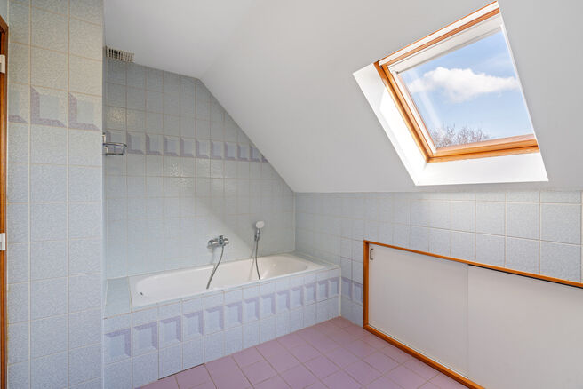 Deze ruime villa met maar liefst 5 slaapkamers en 3 badkamers is gelegen in een residenti&euml;le woonwijk, op een perceel van 15a85ca.

Bij het betreden van de woning komt men in de inkomhal met apart gastentoilet. In 2002 werd de woning uitgebreid met een a