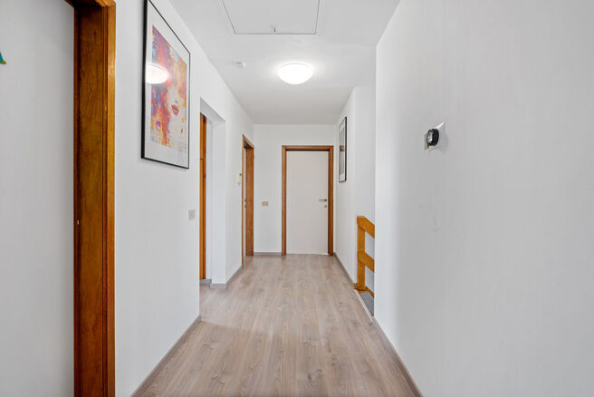 Deze ruime villa met maar liefst 5 slaapkamers en 3 badkamers is gelegen in een residenti&euml;le woonwijk, op een perceel van 15a85ca.

Bij het betreden van de woning komt men in de inkomhal met apart gastentoilet. In 2002 werd de woning uitgebreid met een a