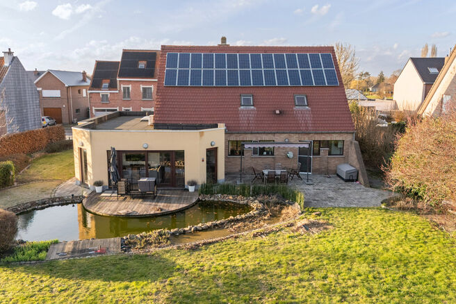 Deze ruime villa met maar liefst 5 slaapkamers en 3 badkamers is gelegen in een residenti&euml;le woonwijk, op een perceel van 15a85ca.

Bij het betreden van de woning komt men in de inkomhal met apart gastentoilet. In 2002 werd de woning uitgebreid met een a