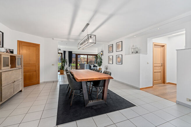 Cette spacieuse villa comprenant pas moins de 5 chambres et 3 salles de bains est situ&eacute;e dans un quartier r&eacute;sidentiel, sur un terrain de 15a85ca.

En entrant dans la maison, vous acc&eacute;dez au hall d&rsquo;entr&eacute;e avec un WC invit&eacute;s s&eacute;par&eacute;. En 2002, la pro