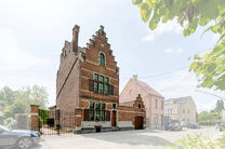 Deze karaktervolle burgerwoning in Vlaamse neotraditionele stijl, met haar statige trapgevel en authentieke elementen, ligt op een royaal perceel van 860 m² in het landelijke Beigem (Grimbergen).

Op het gelijkvloers bevindt zich de inkomhal die toegang 